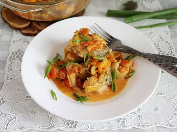 Тушеный морской окунь на сковороде с луком и морковью